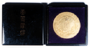 黒い入れ物の中に入れられた金色のメダルの写真