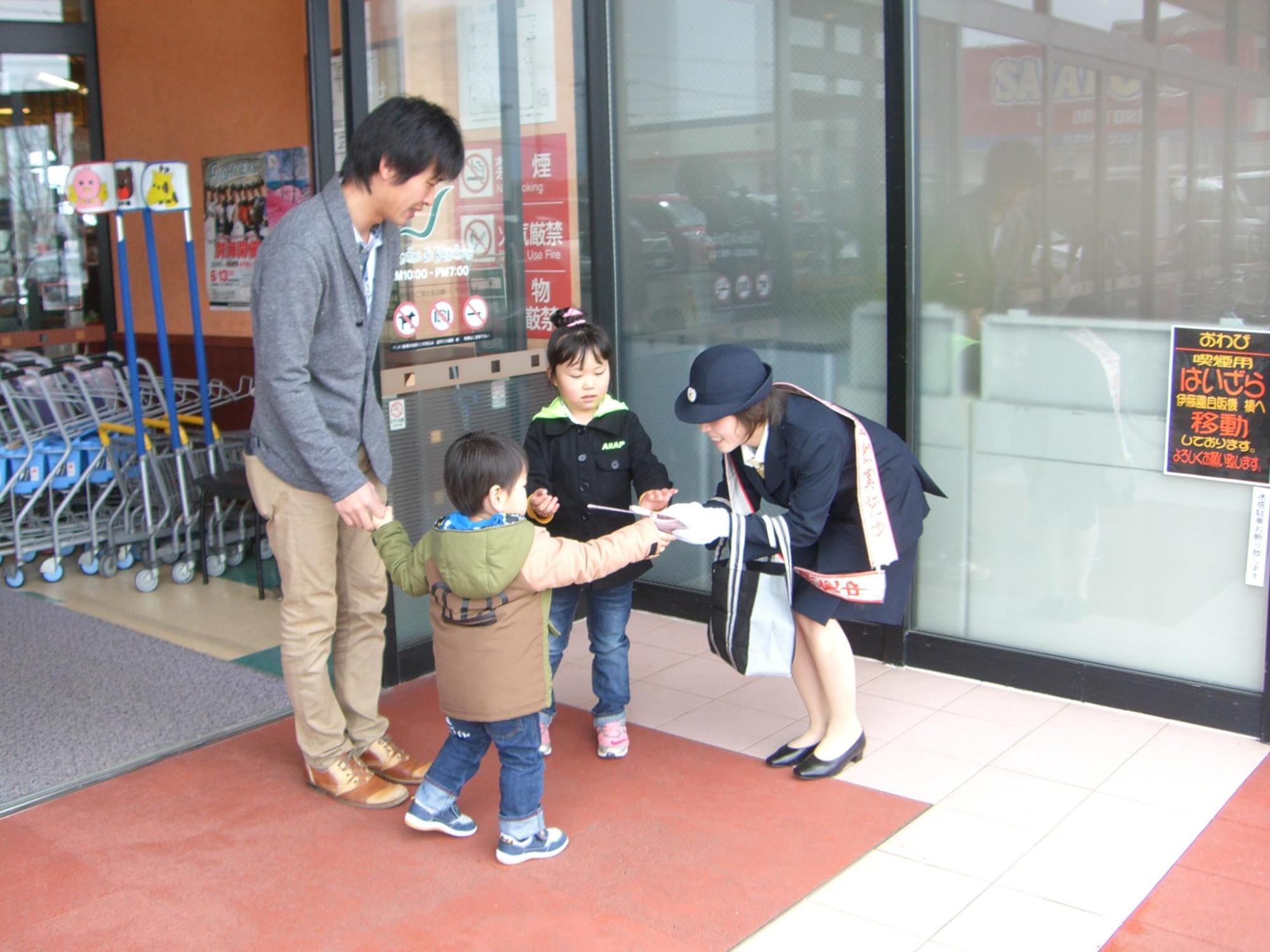 子どもと握手をする女性消防団の写真