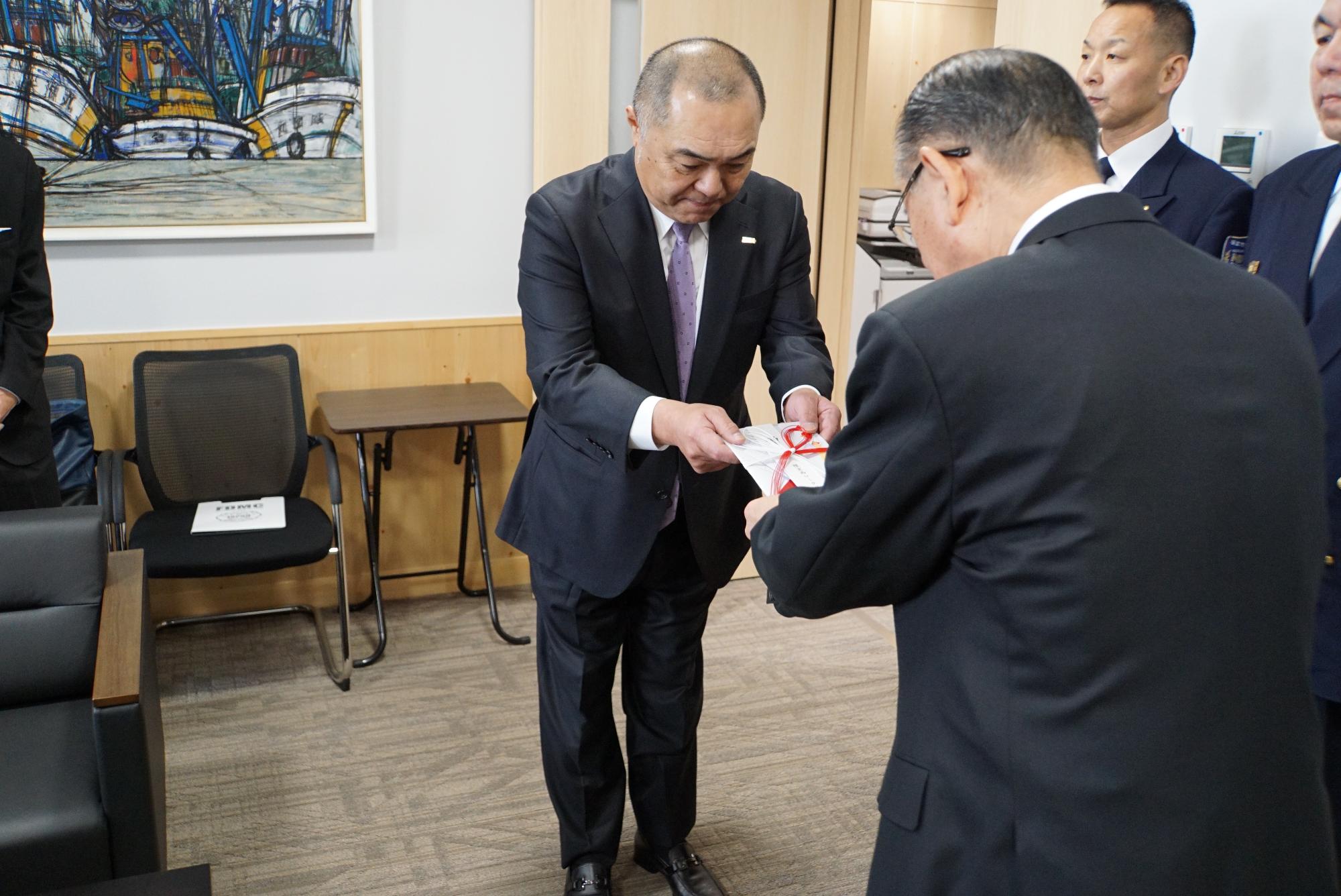 石垣市長に寄付を渡す星会長