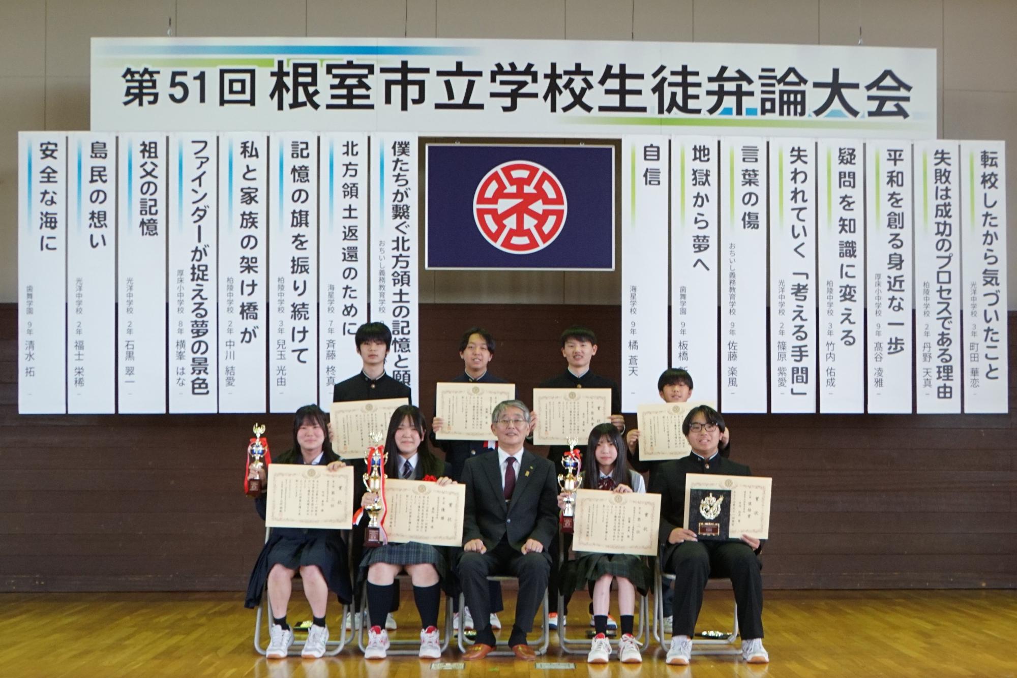 波岸教育長と、賞状を手にする自由課題の部の弁士一同