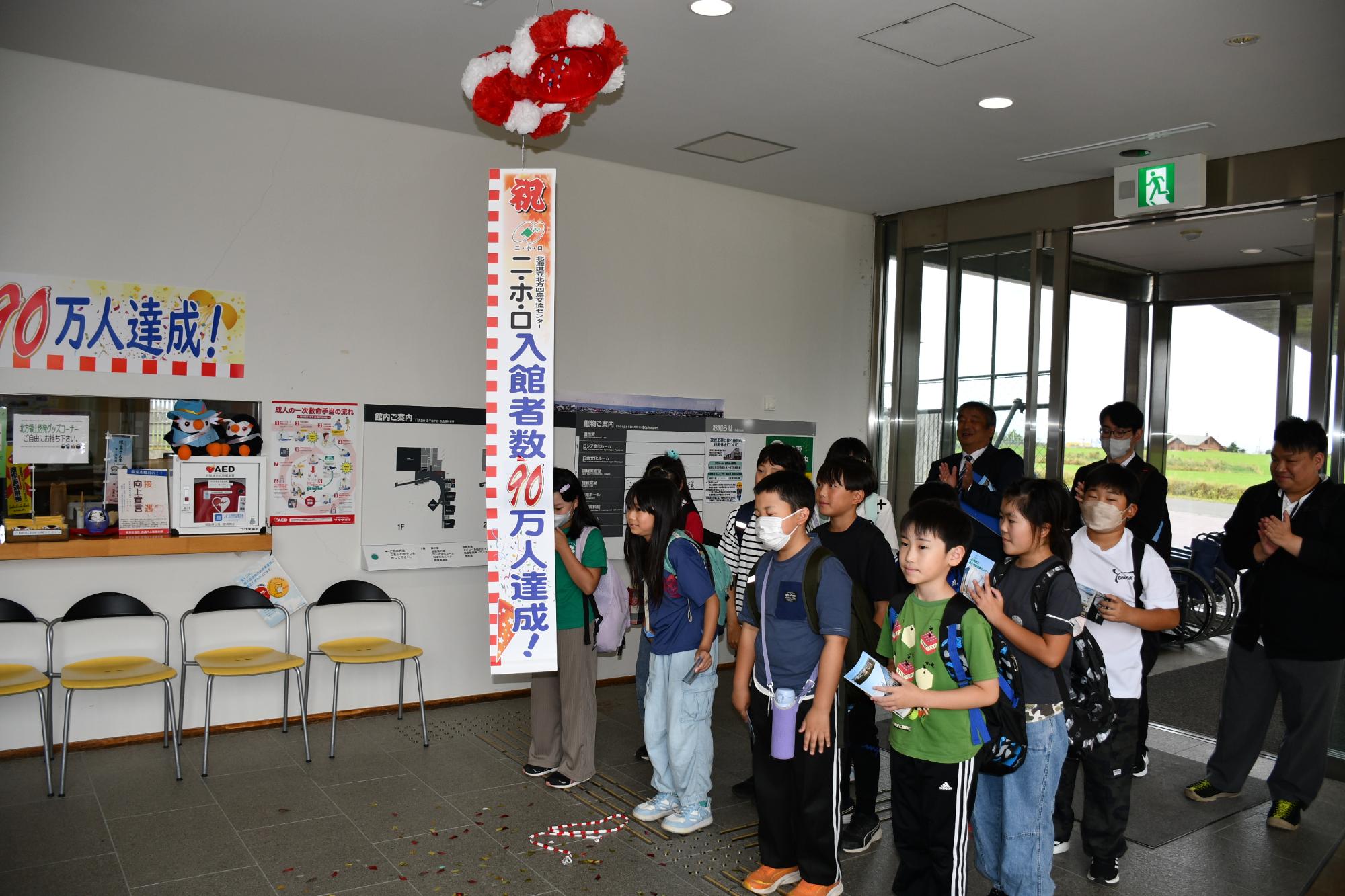 くす玉を割り、90万人達成を祝う厚岸町立厚岸小学校の皆さん